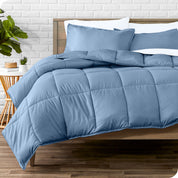 A wooden bed frame with sheets, pillow shams and a comforter on the bed