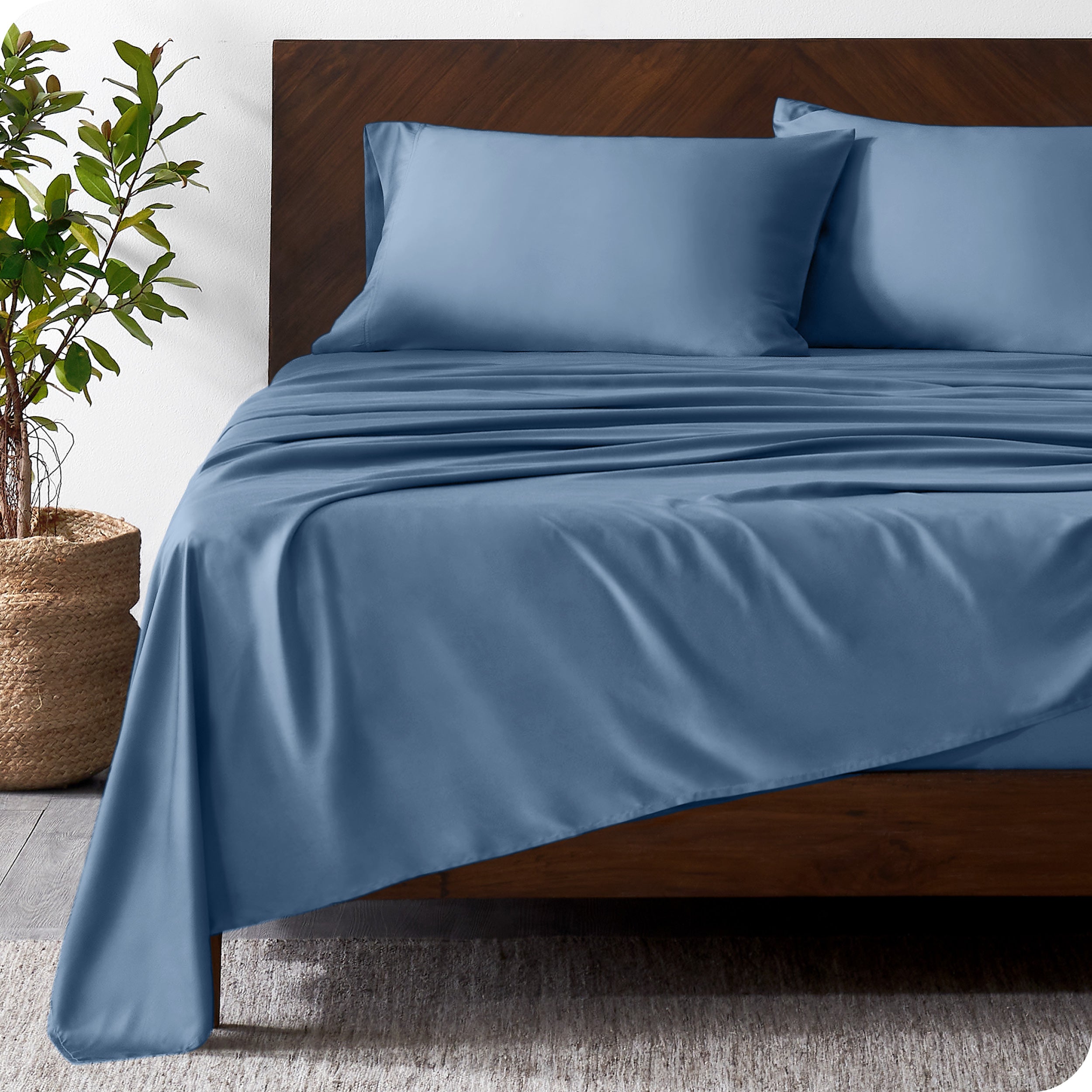 Wooden bed frame with bamboo sheets on the bed