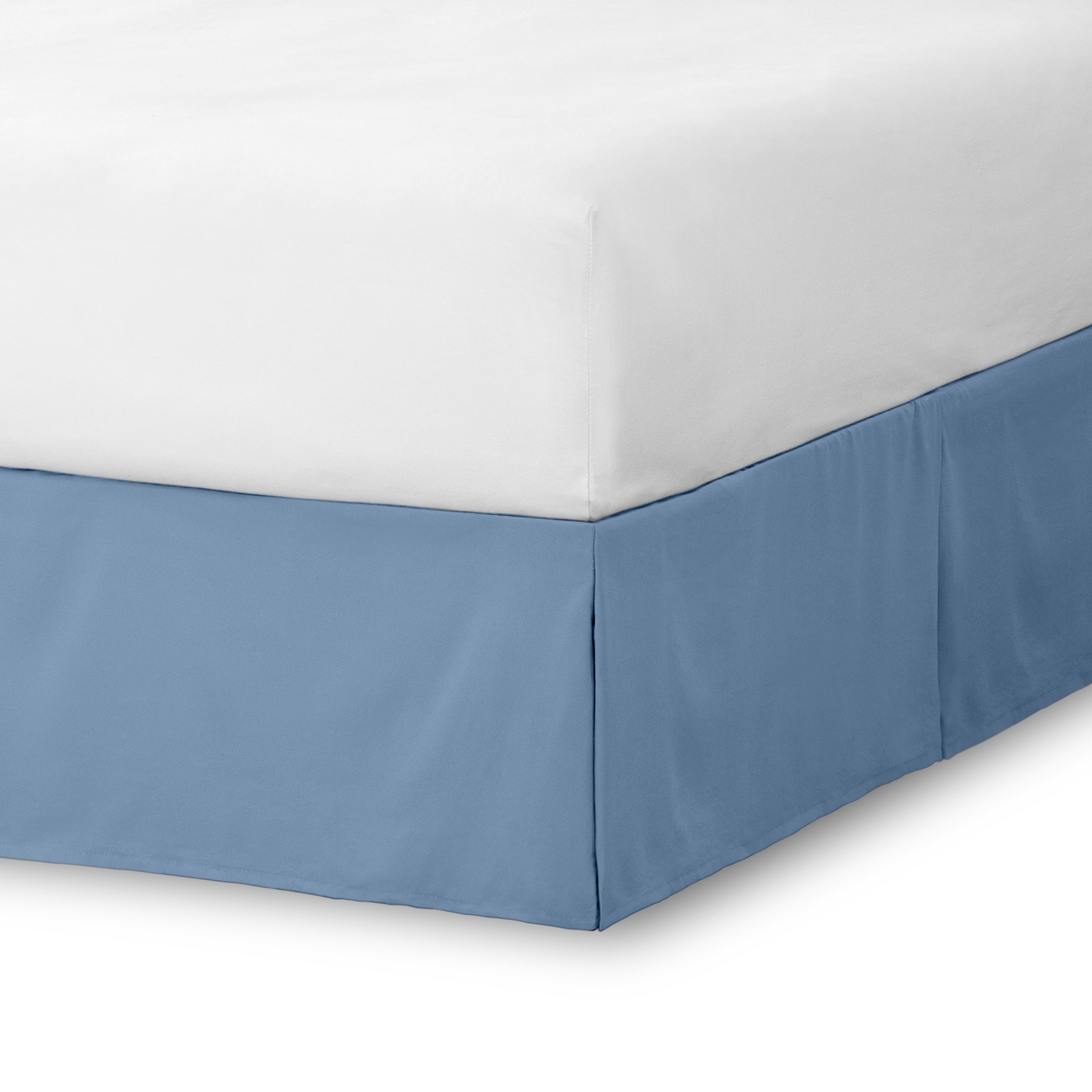 The corner of a bed skirt on a bed frame