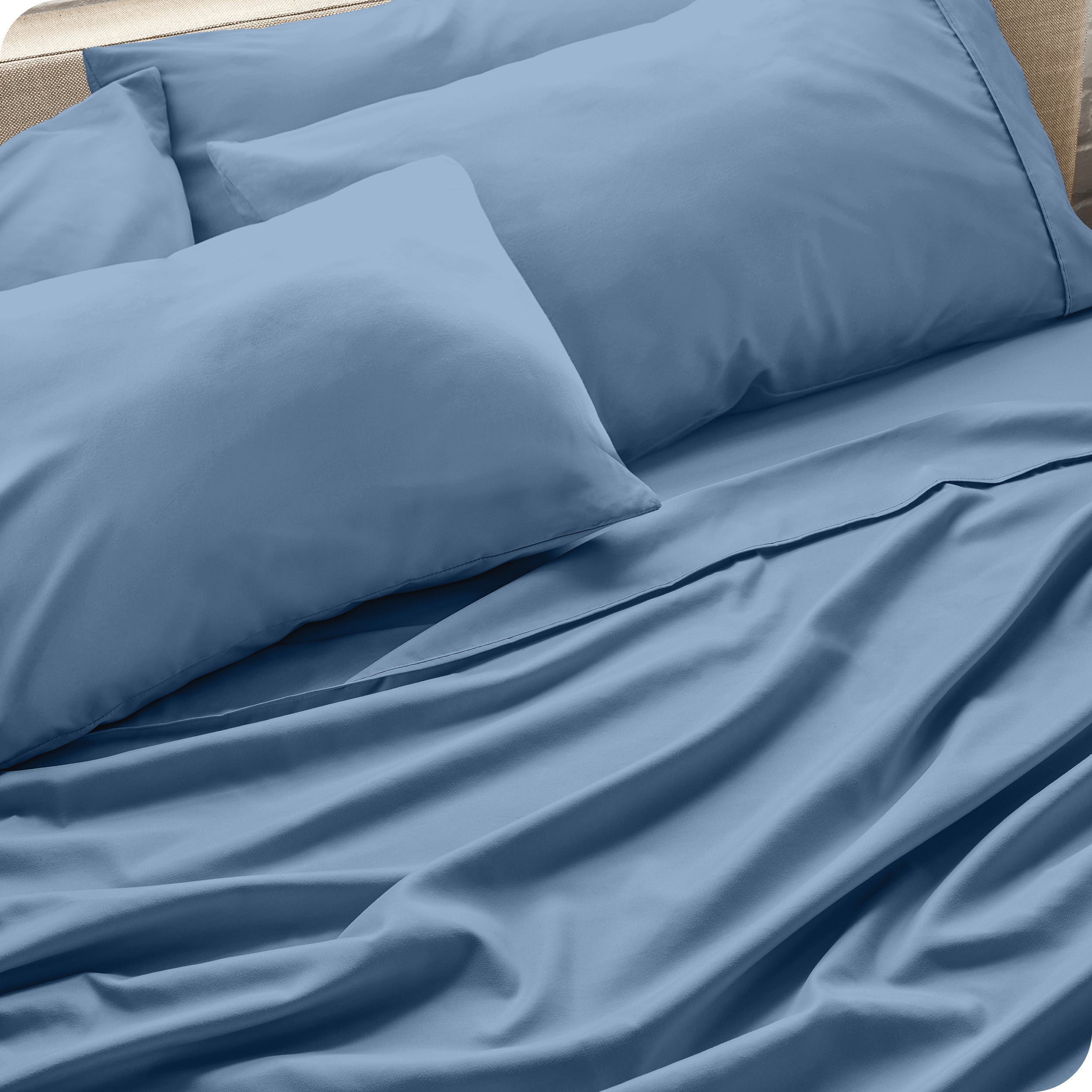 Close up of the microfiber bed sheets on a bed with four pillows.