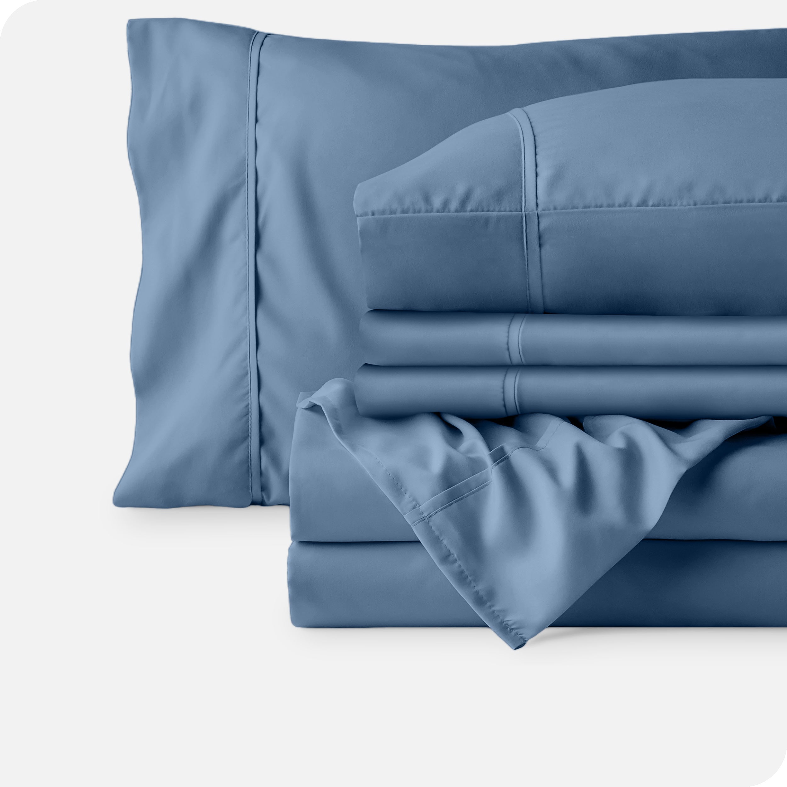 Microfiber sheets neatly folded with corner draped over, two folded pillowcases and two display pillows.