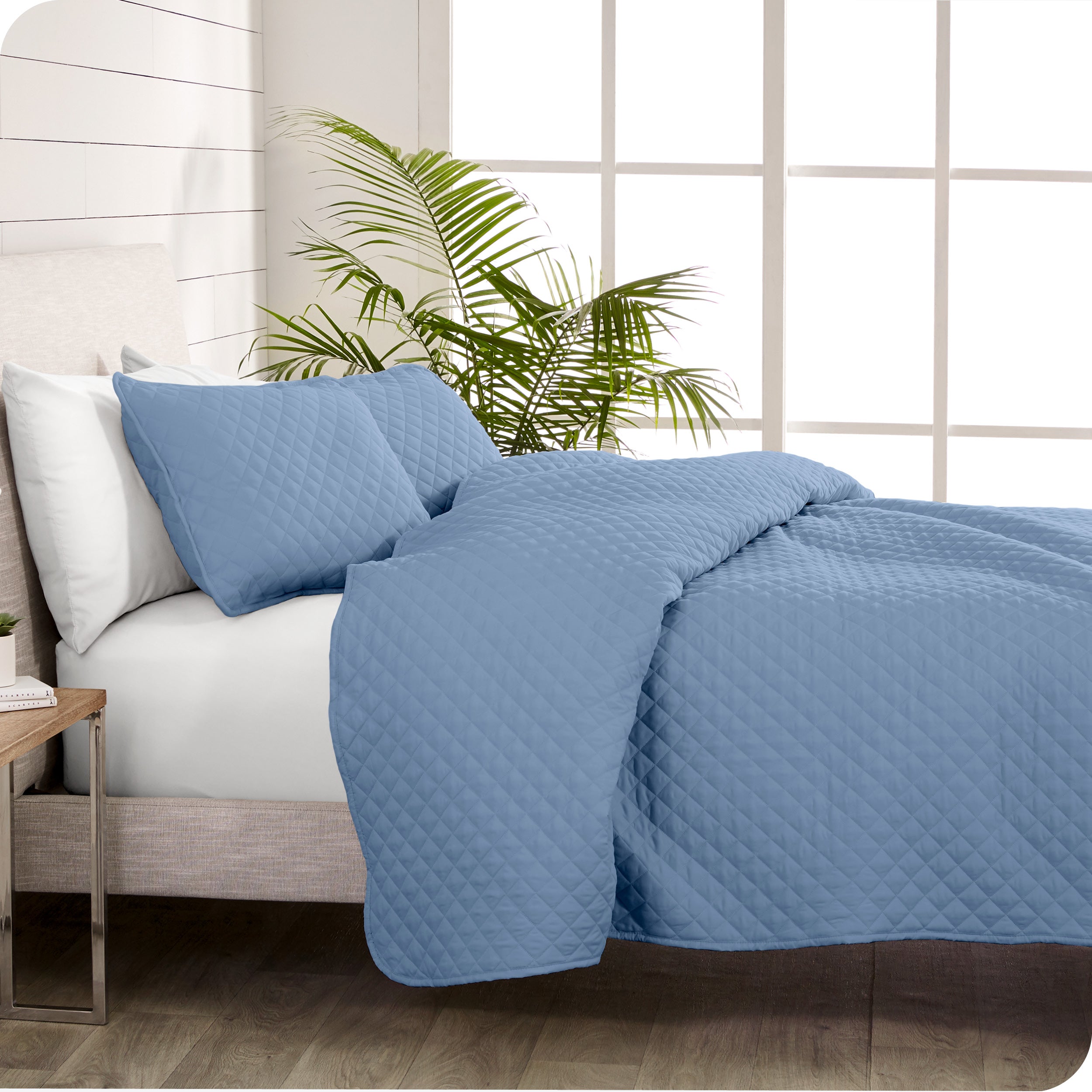 A coverlet set on a bed next to a window