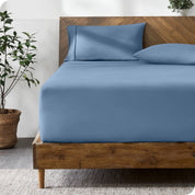 A modern bed with a fitted microfiber sheet made on the mattress. 