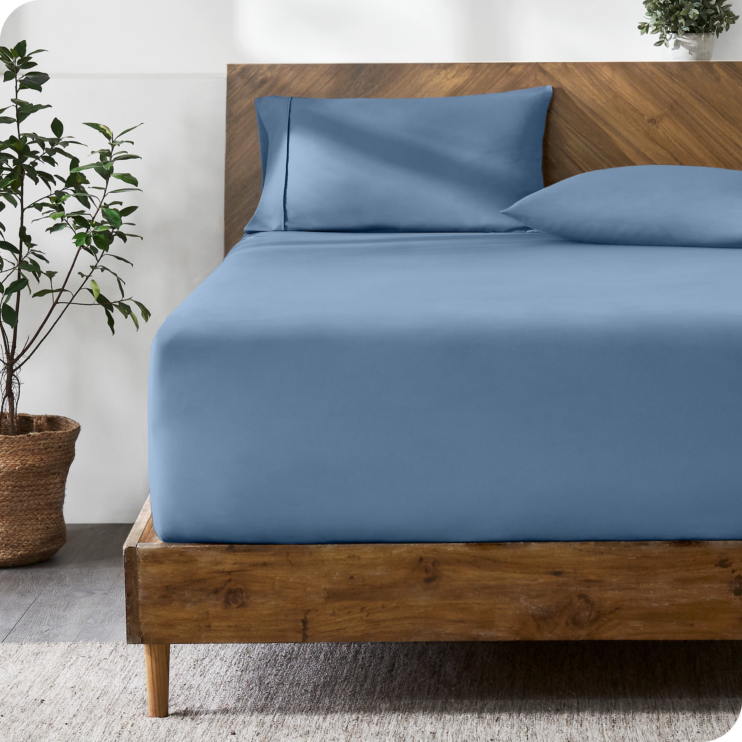 A modern bed with a fitted microfiber sheet made on the mattress. 