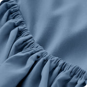 A modern bed with a fitted microfiber sheet on it