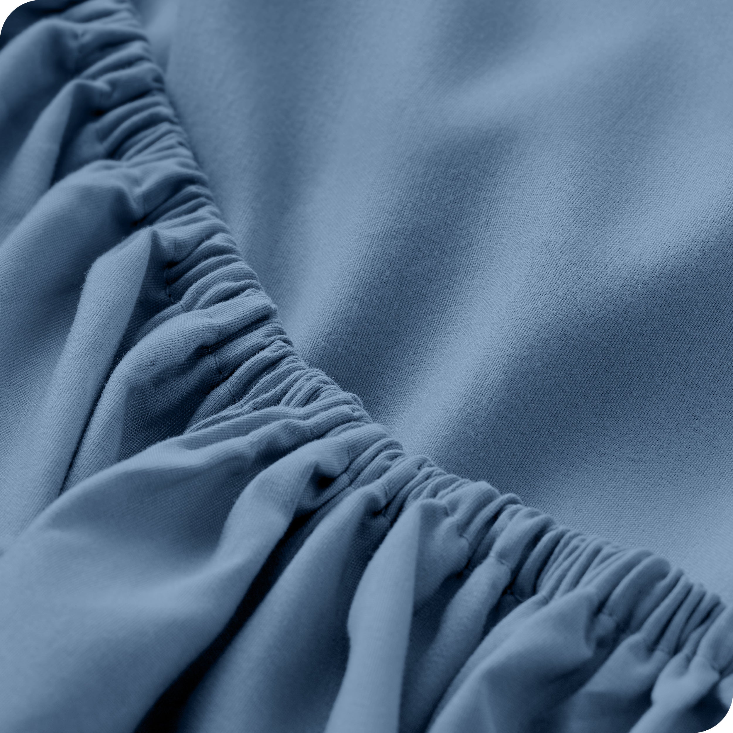 A modern bed with a fitted microfiber sheet on it