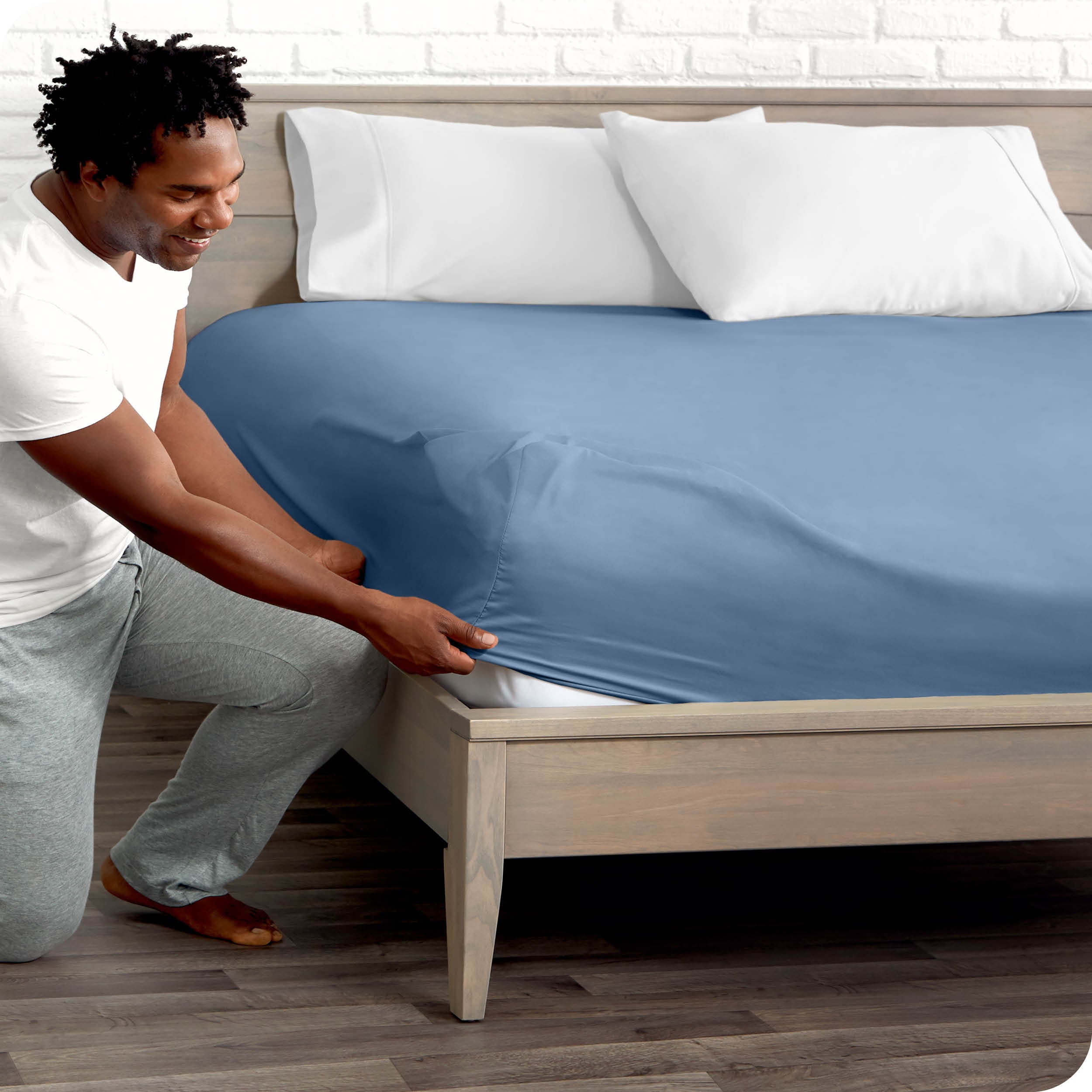 A man putting the microfiber fitted sheet on a mattress. 