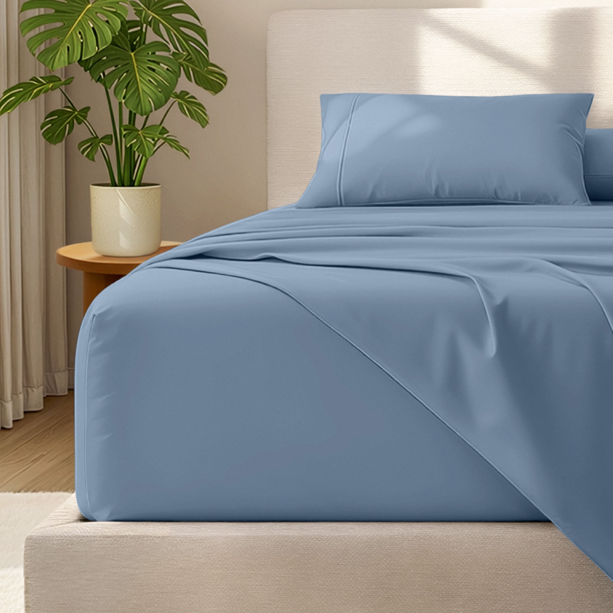 Microfiber bed sheets and pillowcases on a bed with a plant in the background