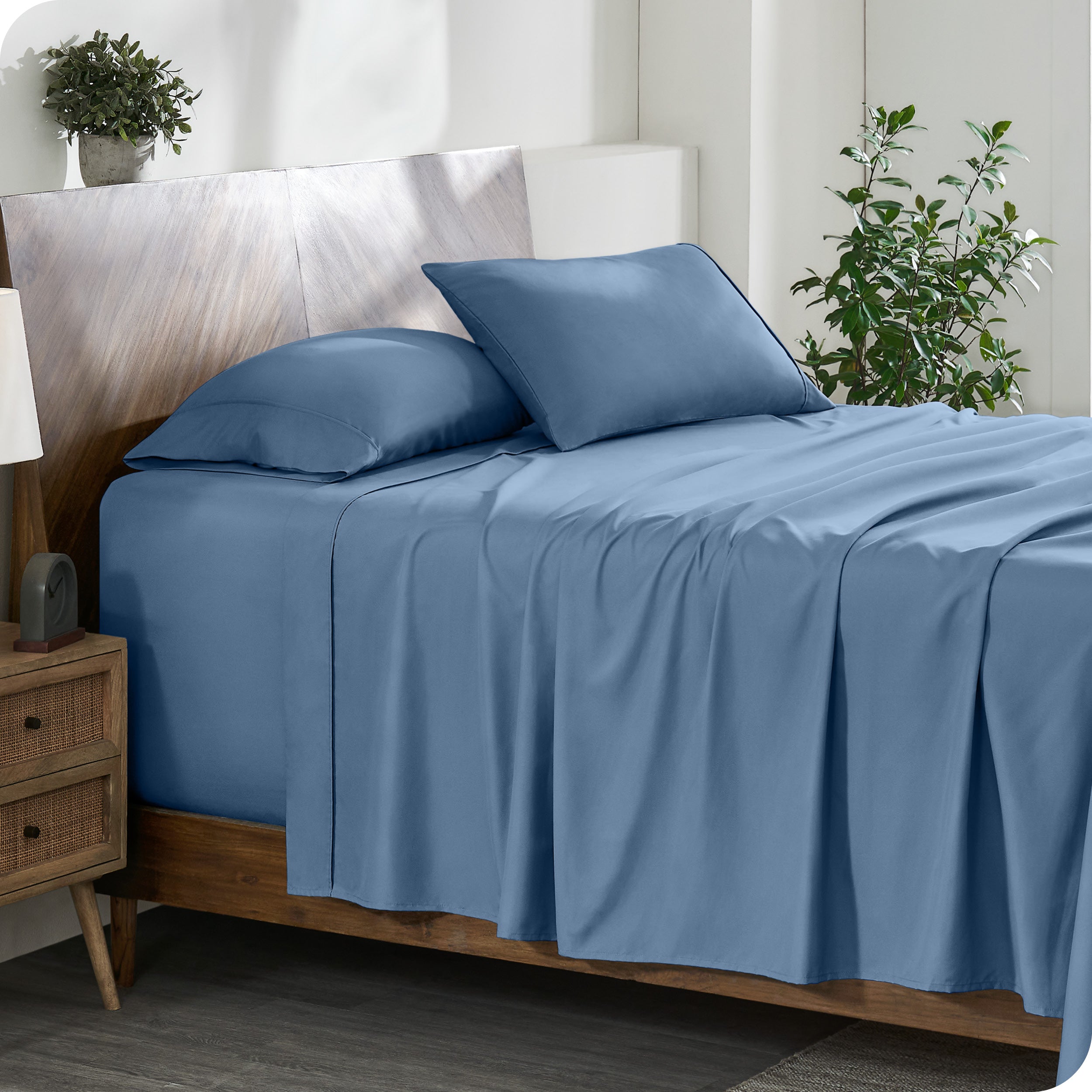 A cozy bedroom featuring a neatly made bed with soft, microfiber sheets