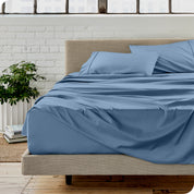 Microfiber sheets on a bed with a brick wall behind it