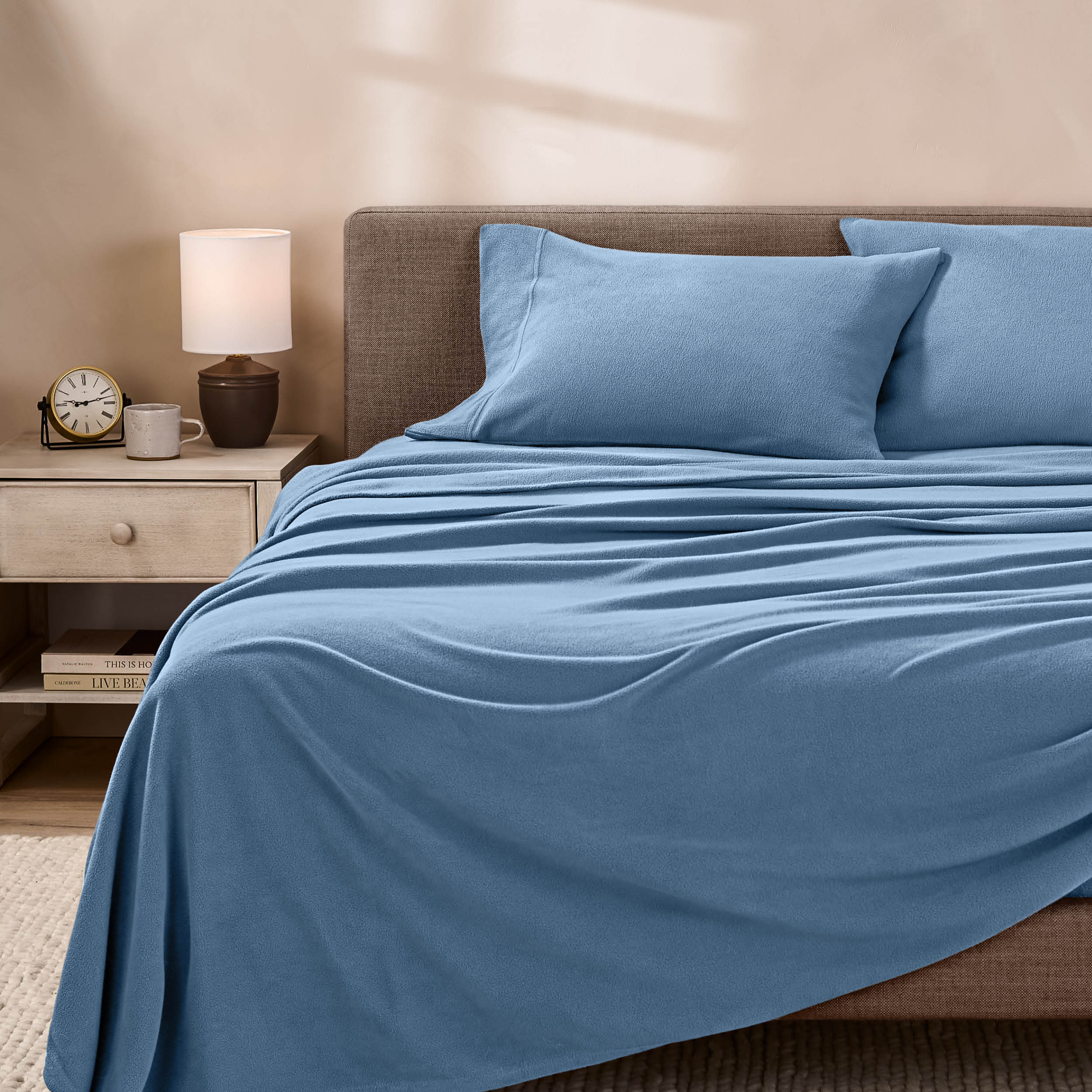 View of fleece sheets from the end of a bed with the top sheet draped over the side and end