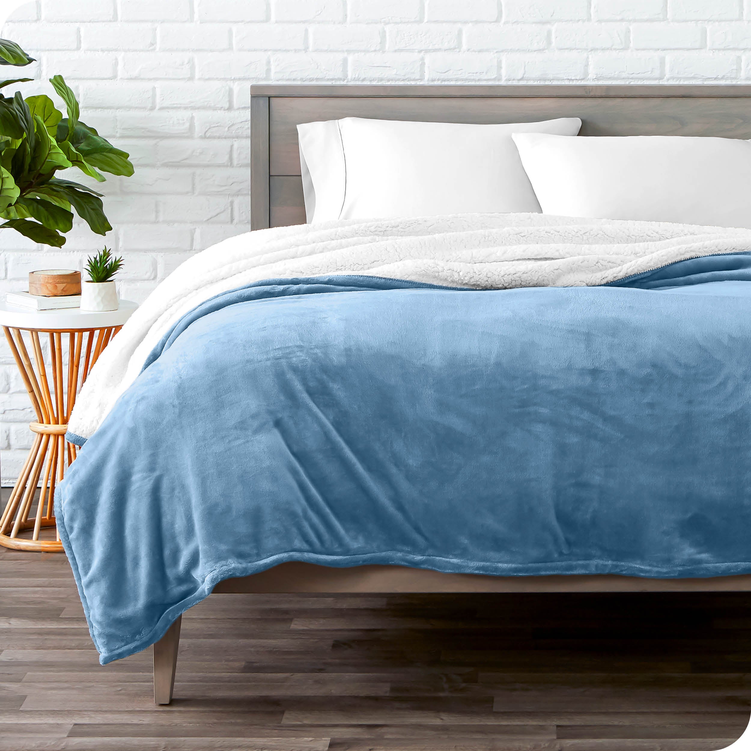 Coronet Blue Sherpa Blanket laying on a bed folded over itself part way