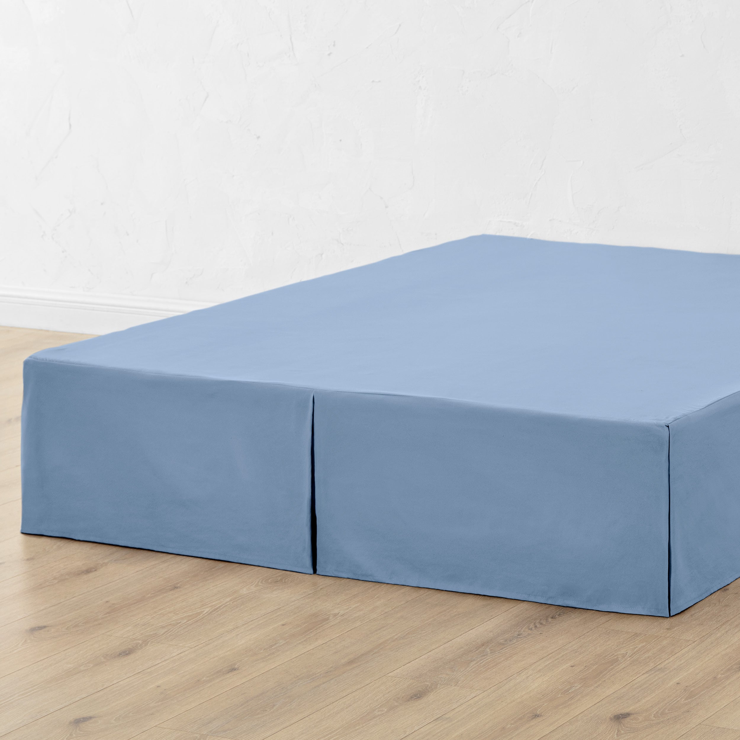 A bed skirt draped over a box spring
