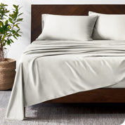 Wooden bed frame with bamboo sheets on the bed