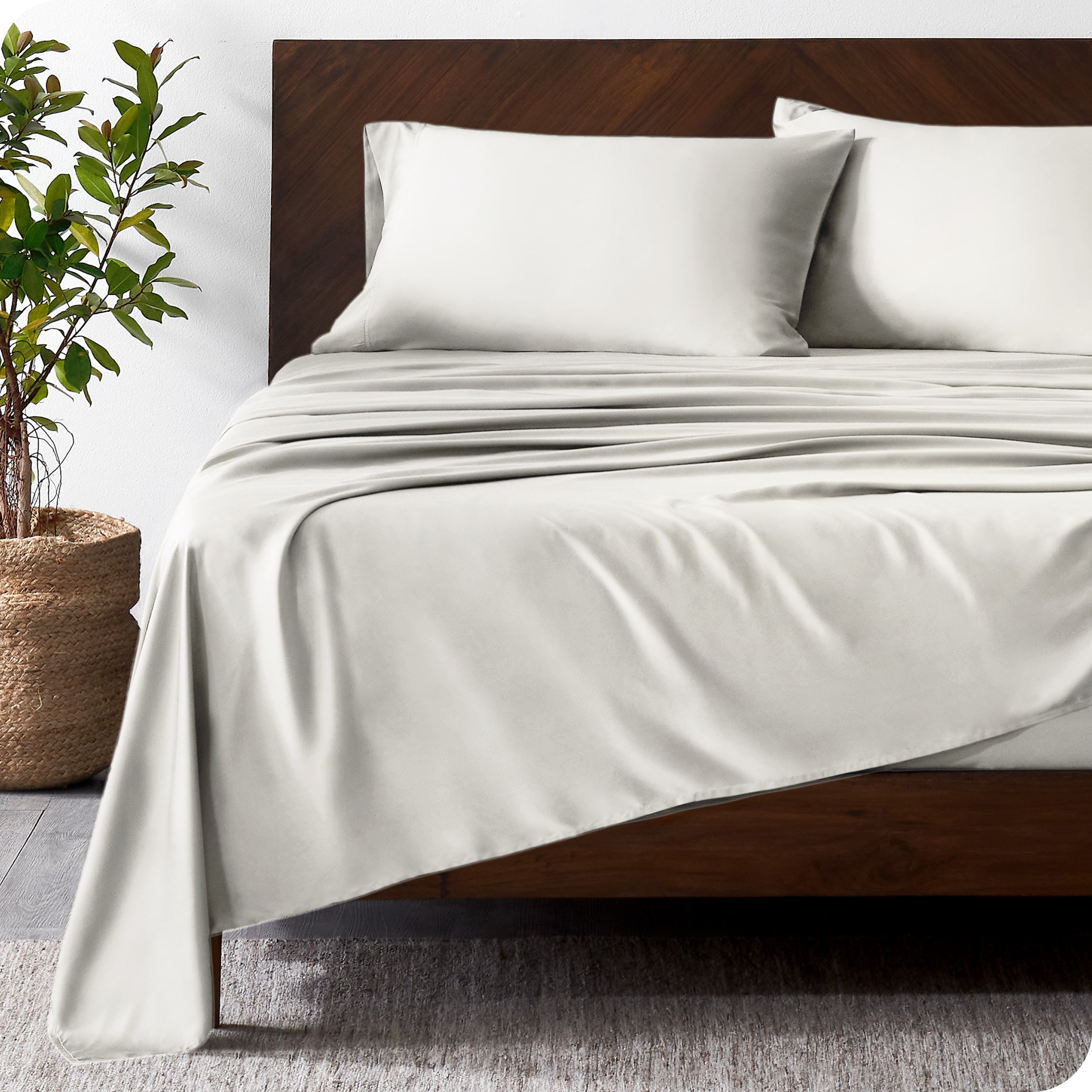Wooden bed frame with bamboo sheets on the bed