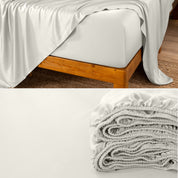 Bamboo fitted sheet on a wooden bed with a close-up of the folded sheet below.