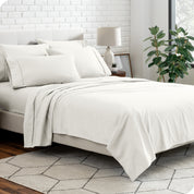 A bedroom setting with a bed made with the microfiber bed sheets and four pillows.