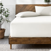 A modern bed with a fitted microfiber sheet made on the mattress. 