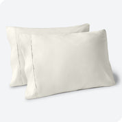 Two pillows on a white background with blue pillowcases on them