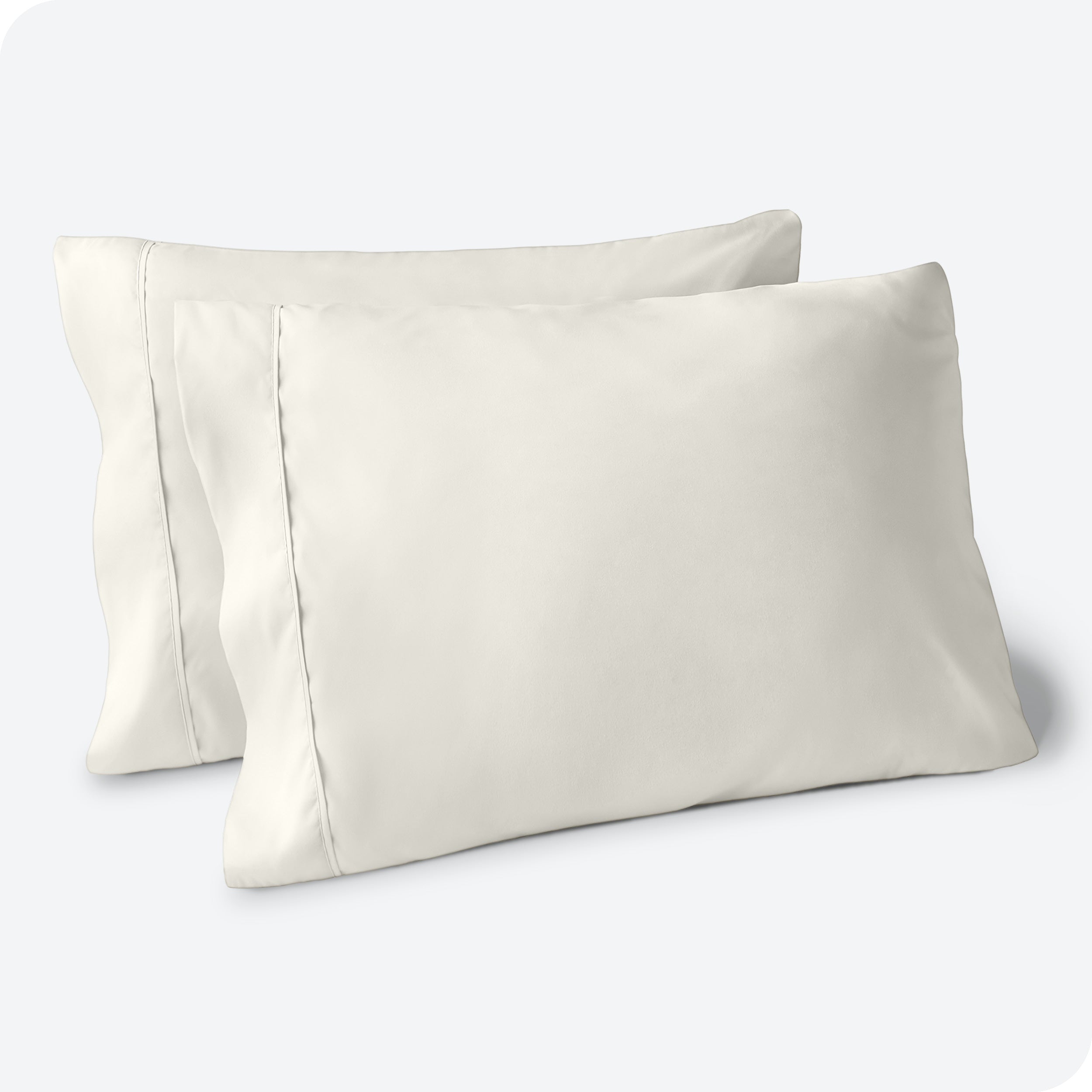 Two pillows on a white background with blue pillowcases on them