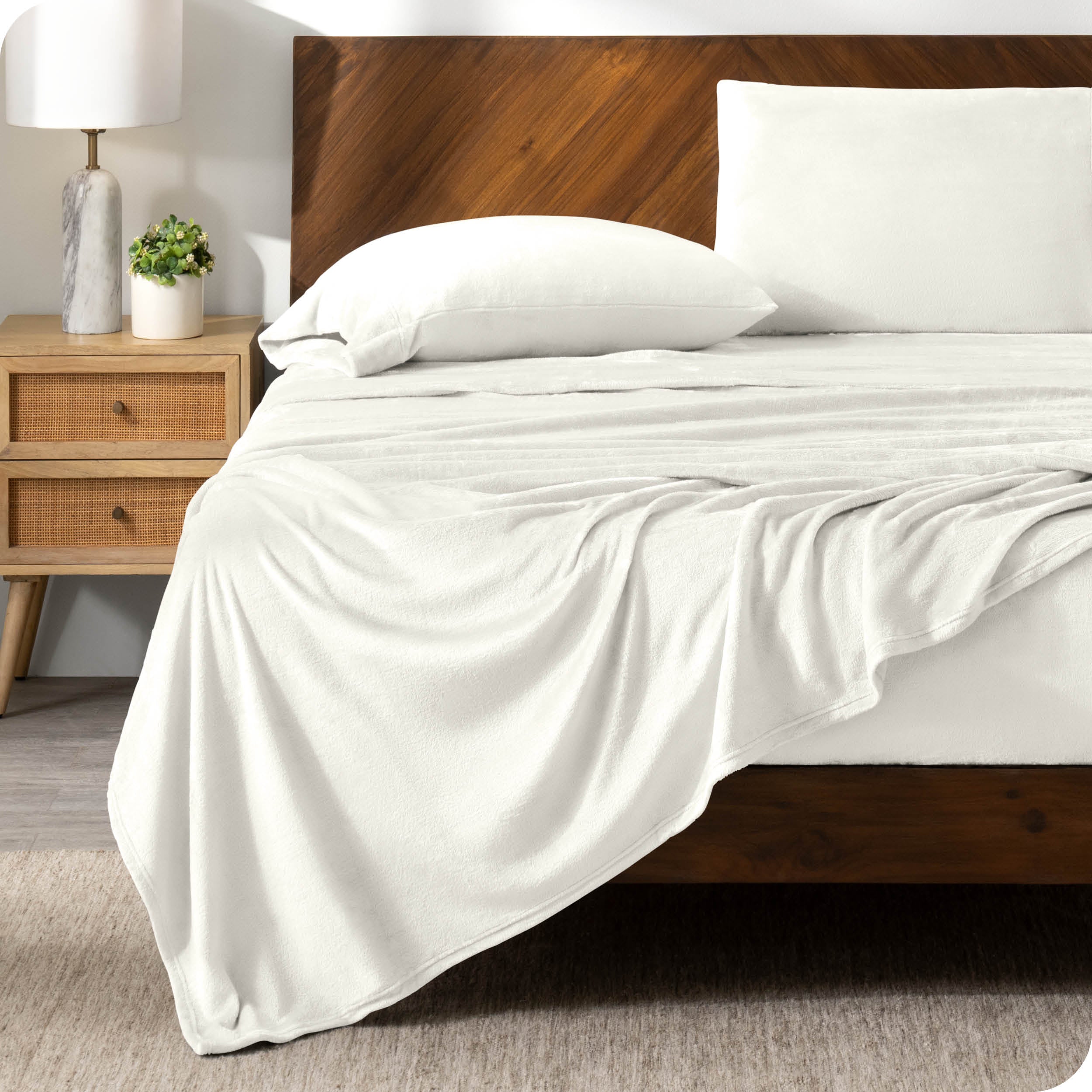A cream sheet set on a bed with a wooden bed frame