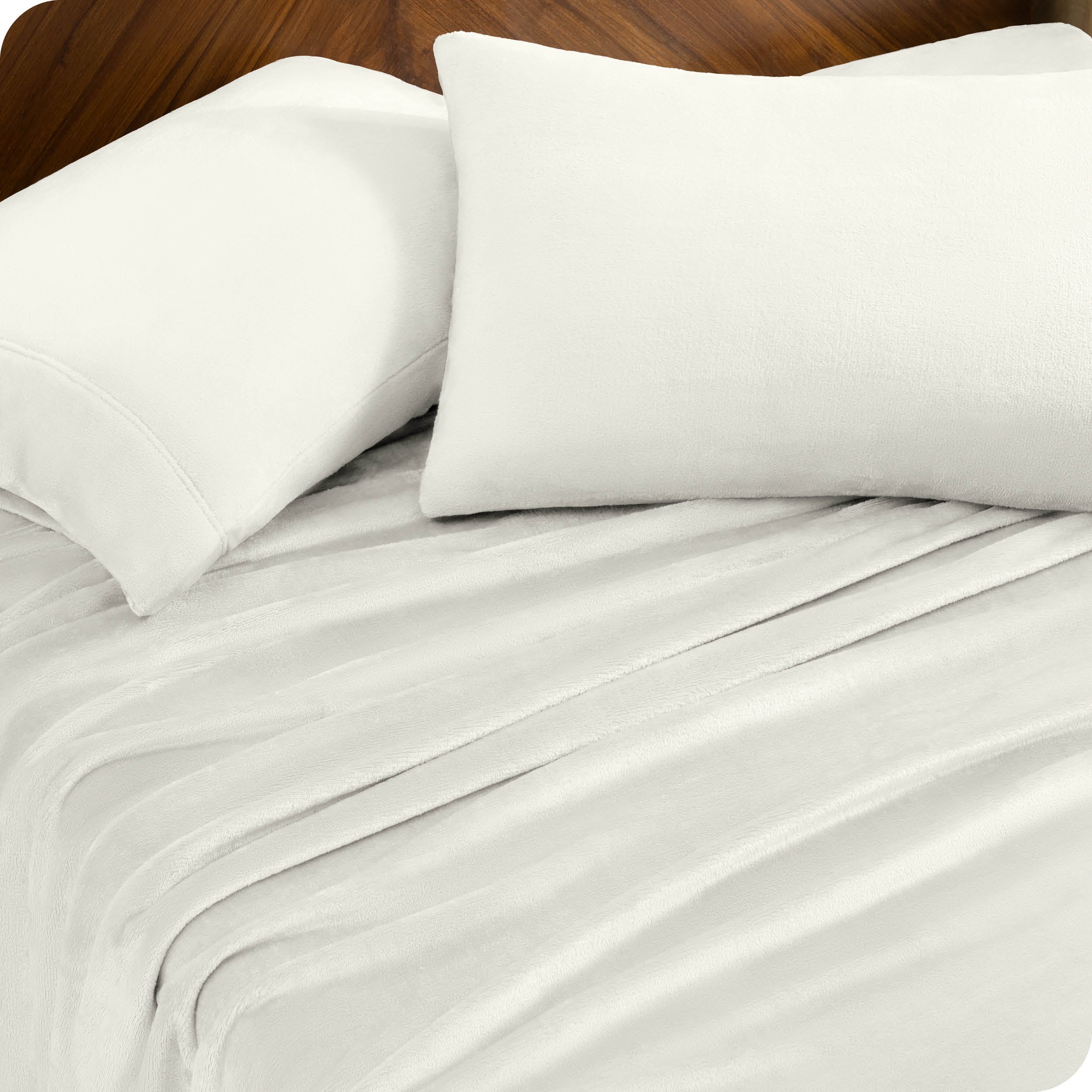 Two pillows with pillowcases on them set on a bed with matching sheets