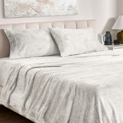 Microplush bed sheets and pillowcases on a bed with a neutral headboard and decor.