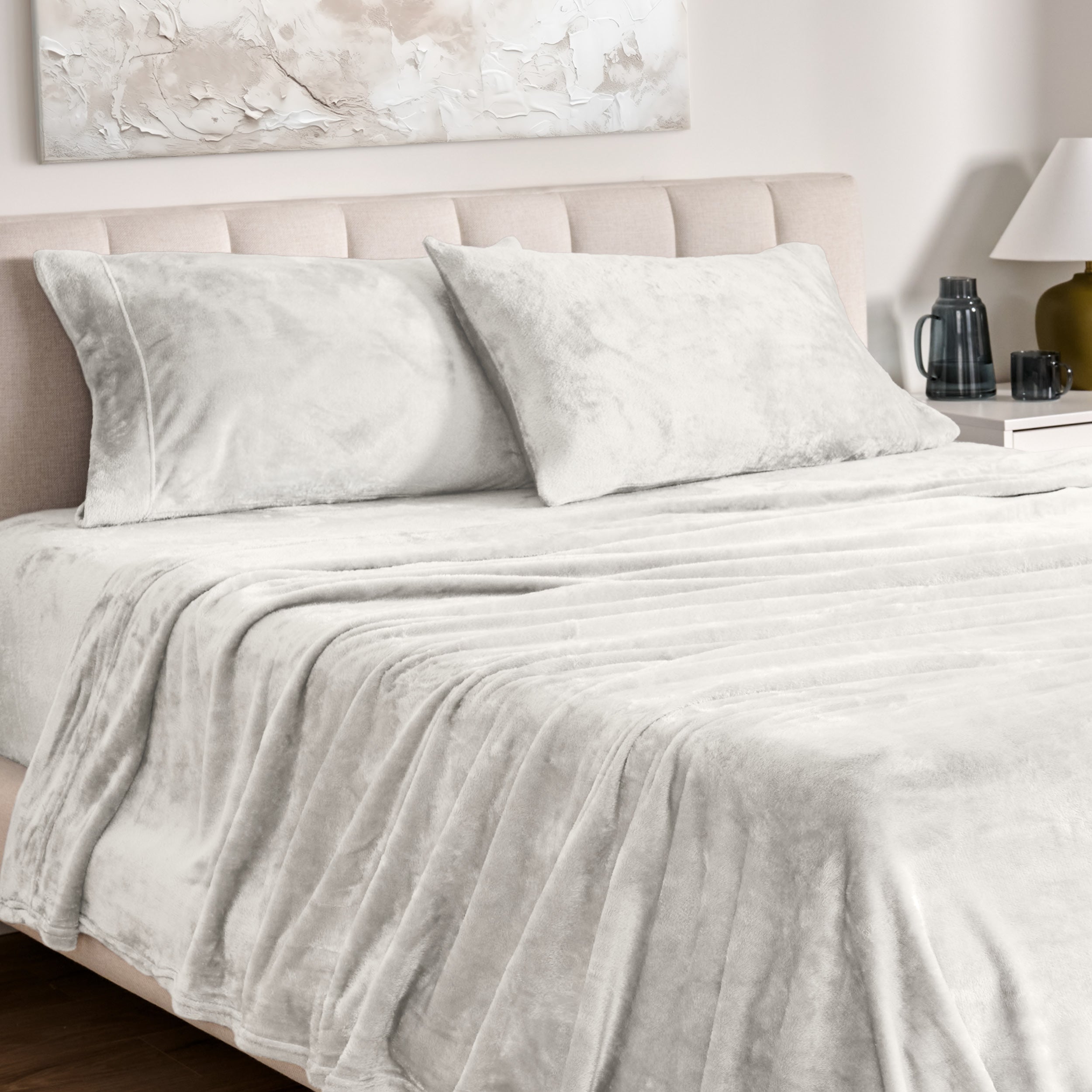 Microplush bed sheets and pillowcases on a bed with a neutral headboard and decor.
