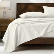 Percale sheet set on a bed with a wooden headboard