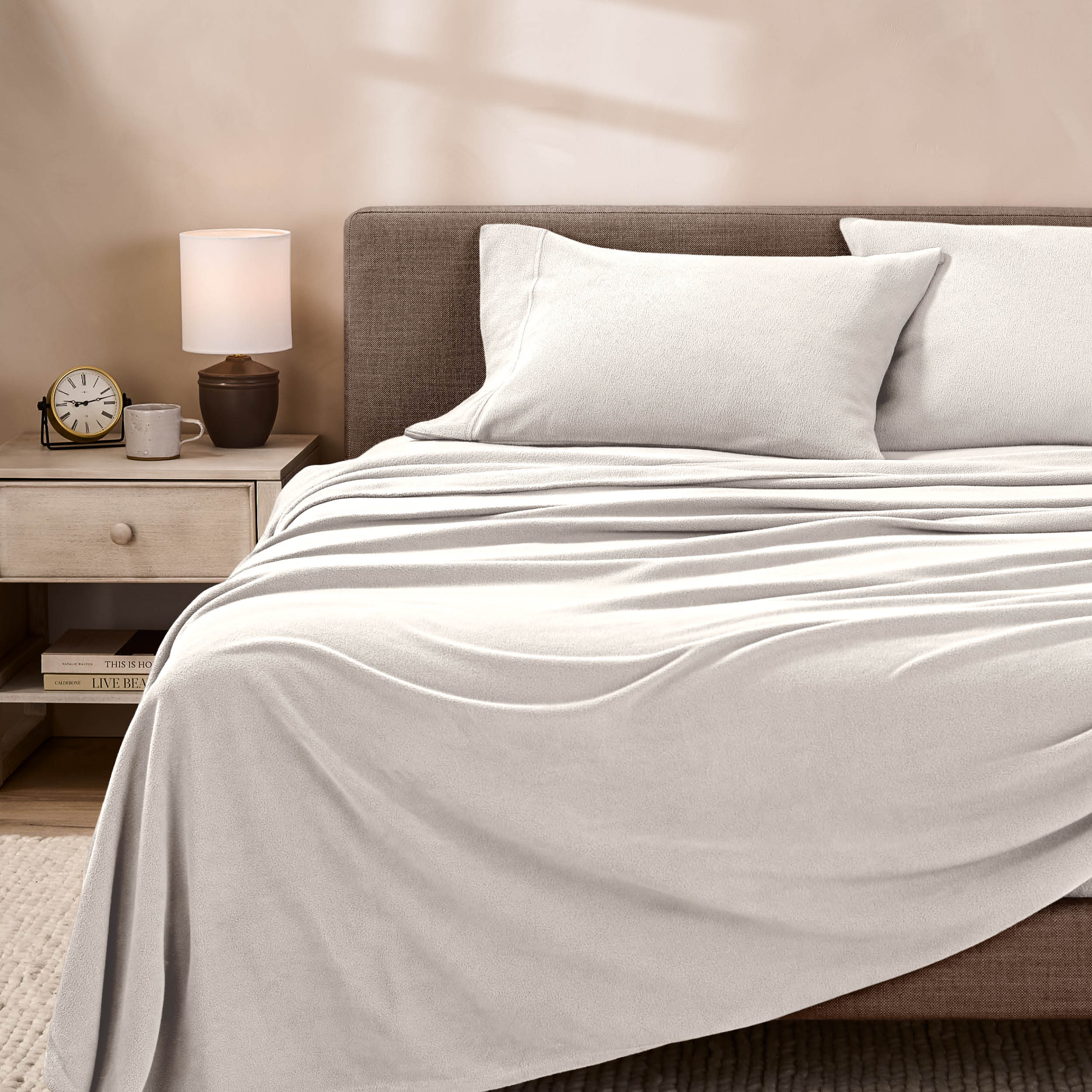 View of fleece sheets from the end of a bed with the top sheet draped over the side and end