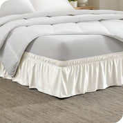 The corner of a bed with a polyester bed skirt on it