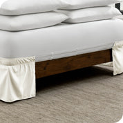 The adjustable elastic belt of a bed skirt wrapped around the mattress