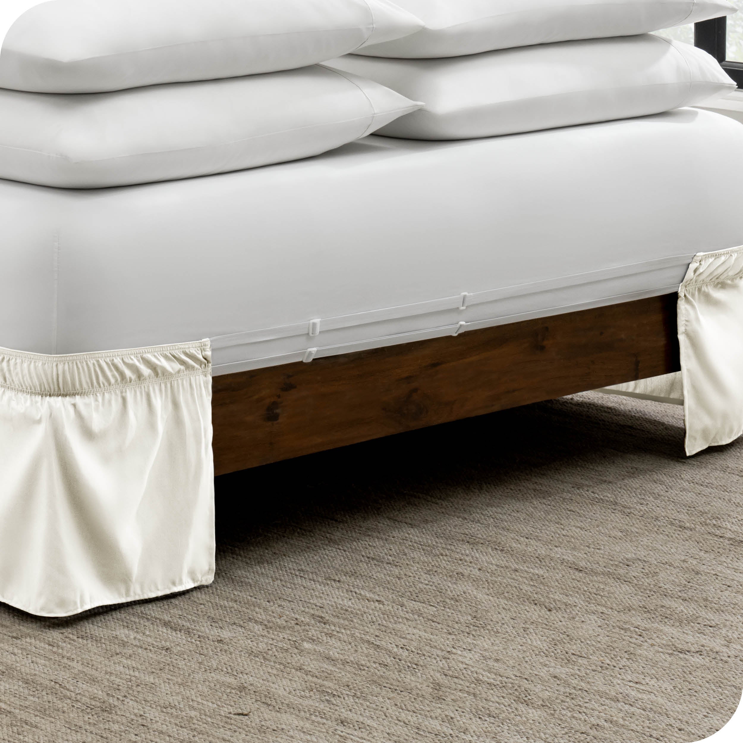 The adjustable elastic belt of a bed skirt wrapped around the mattress