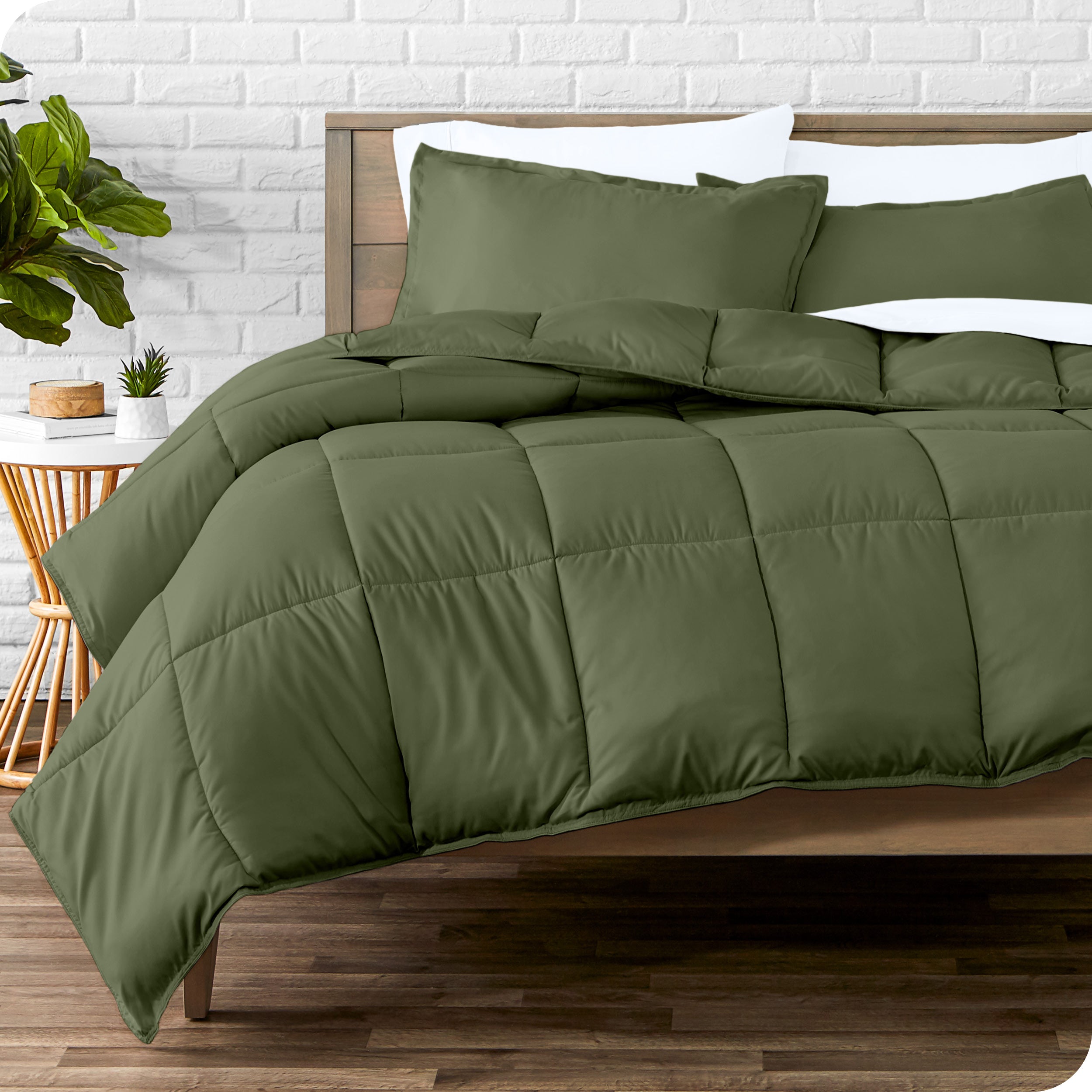 A wooden bed frame with sheets, pillow shams and a comforter on the bed