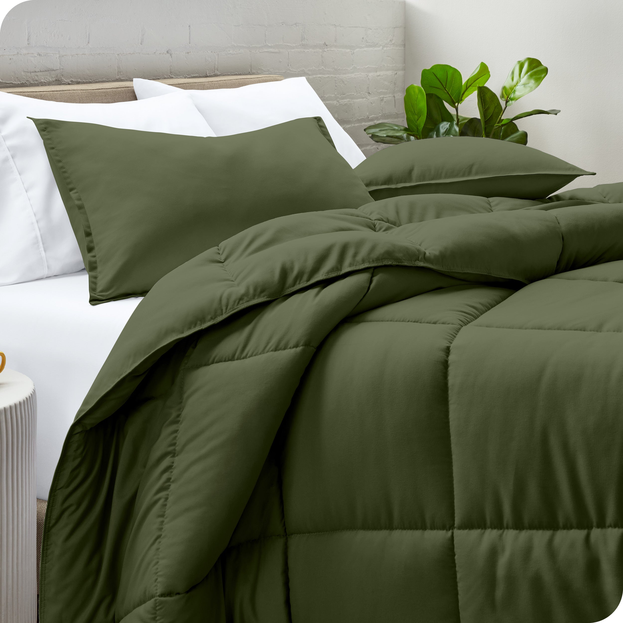 A side view of a modern bed with a comforter set and pillows on the bed
