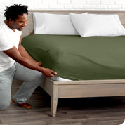 A man putting the microfiber fitted sheet on a mattress. 