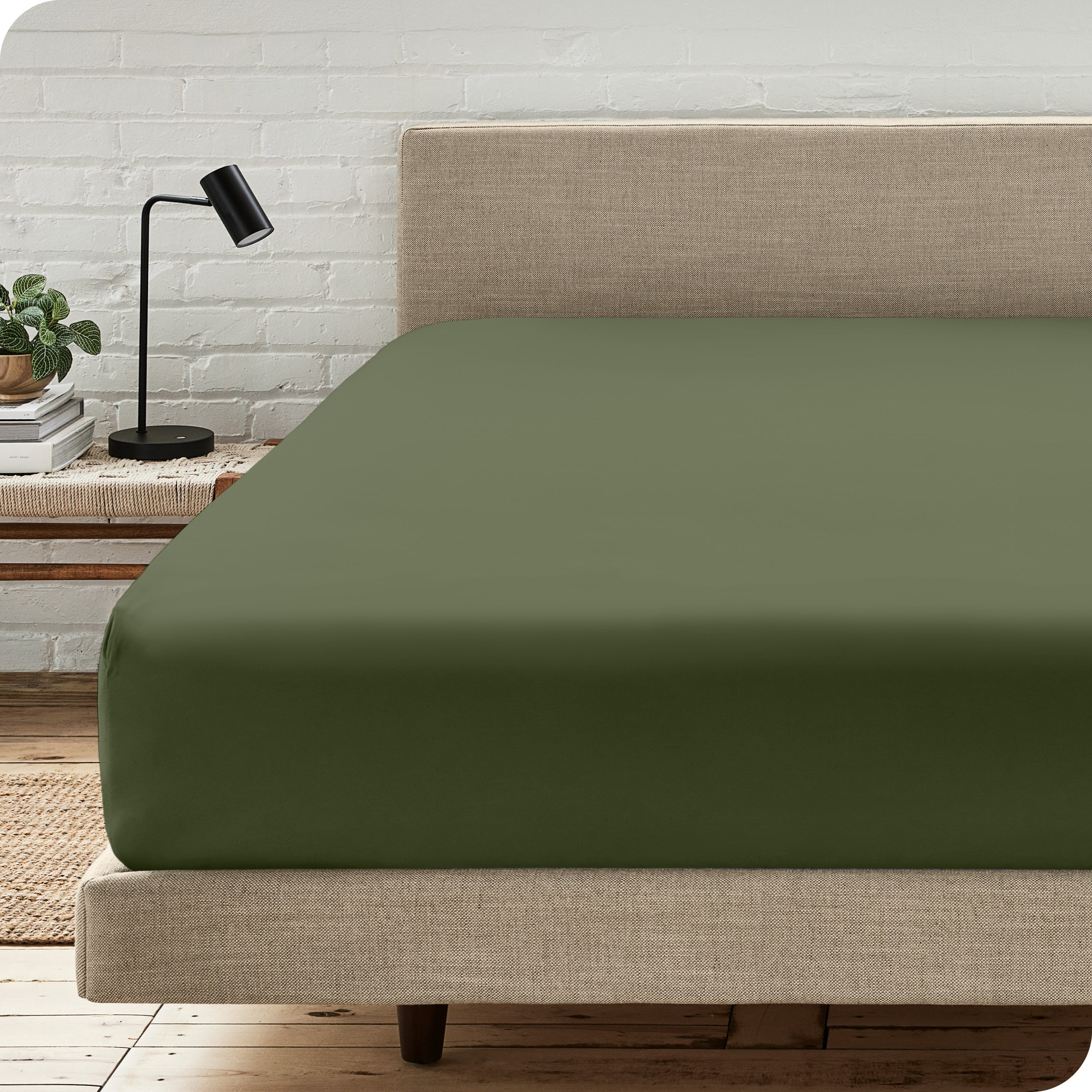 A bed with a microfiber fitted sheet on the mattress. 