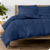 A wooden bed frame with sheets, pillow shams and a comforter on the bed