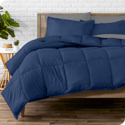A wooden bed frame with sheets, pillow shams and a comforter on the bed