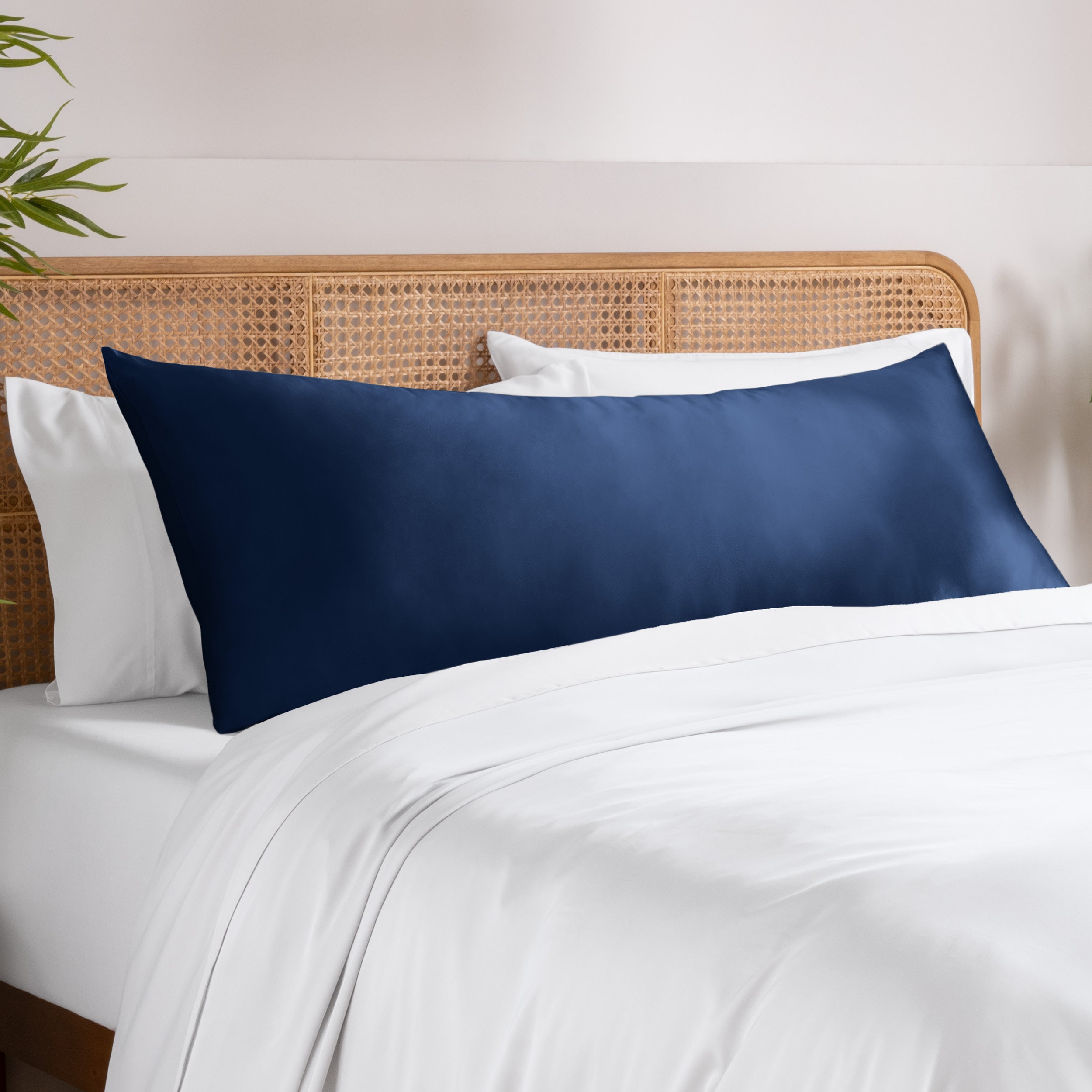 Bamboo pillowcase on a bed with white bedding and a wooden headboard.