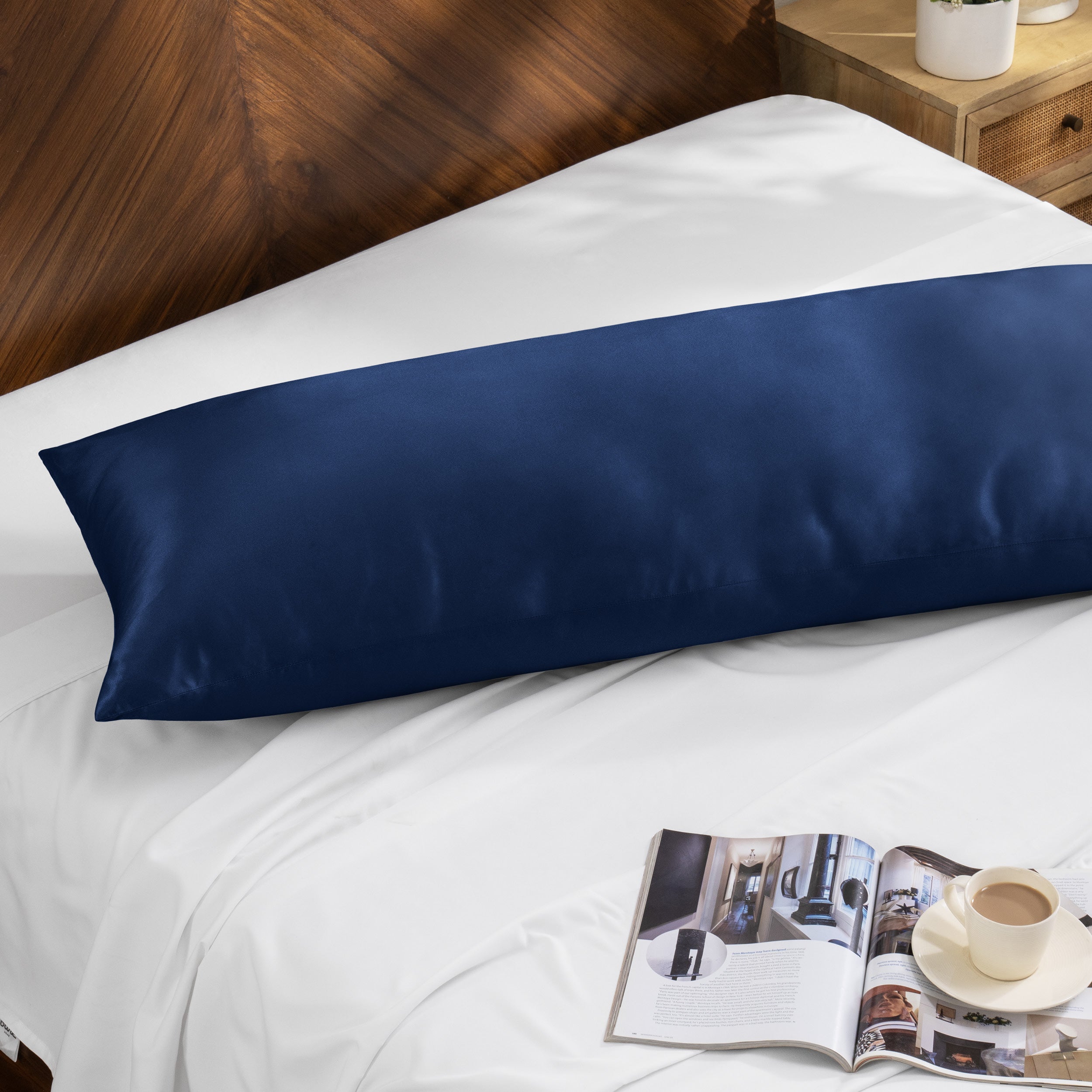 Bamboo body pillow on a bed with a magazine and cup of coffee nearby.