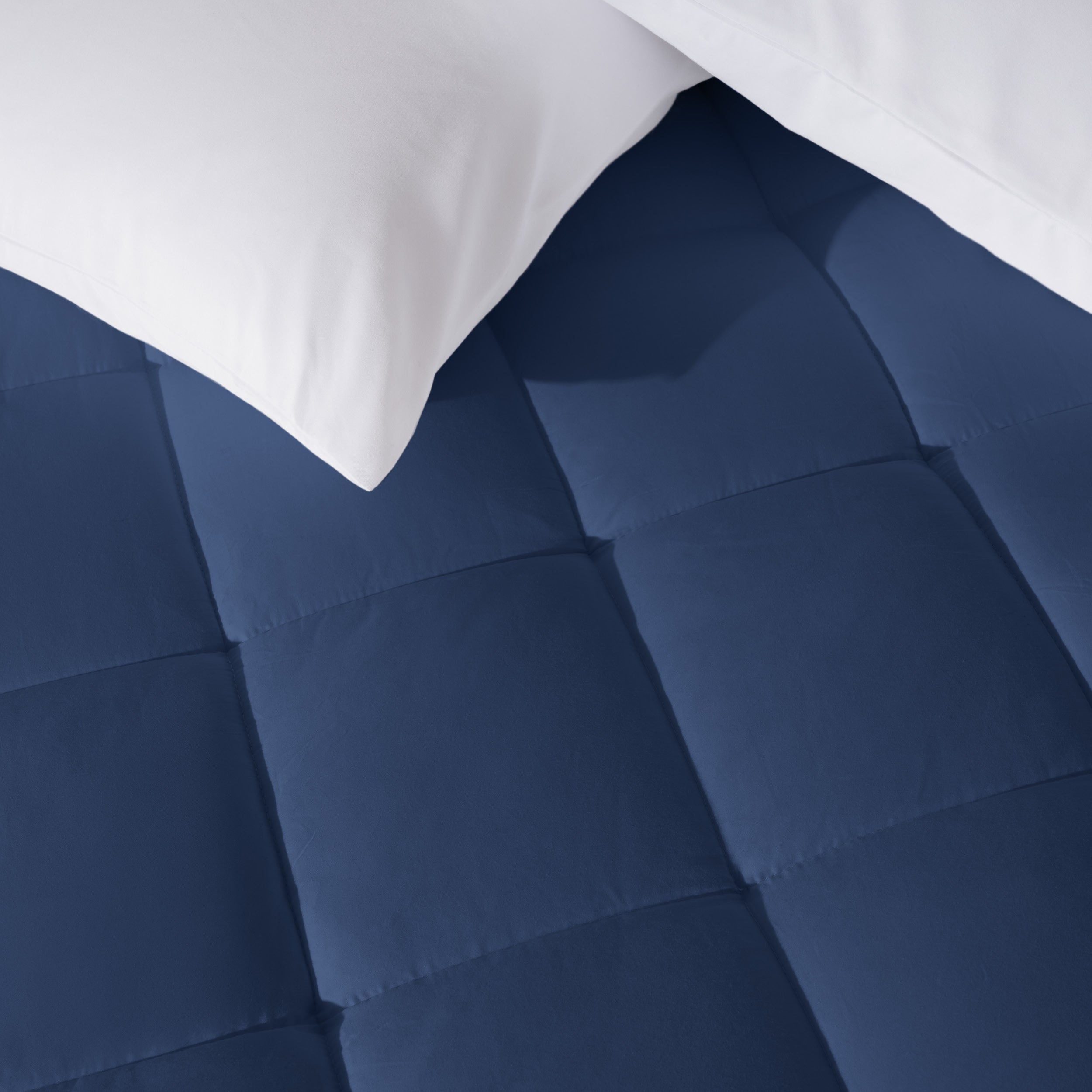 Close up of a cotton top mattress pad with pillows from above.