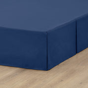 A box spring with a bed skirt on it