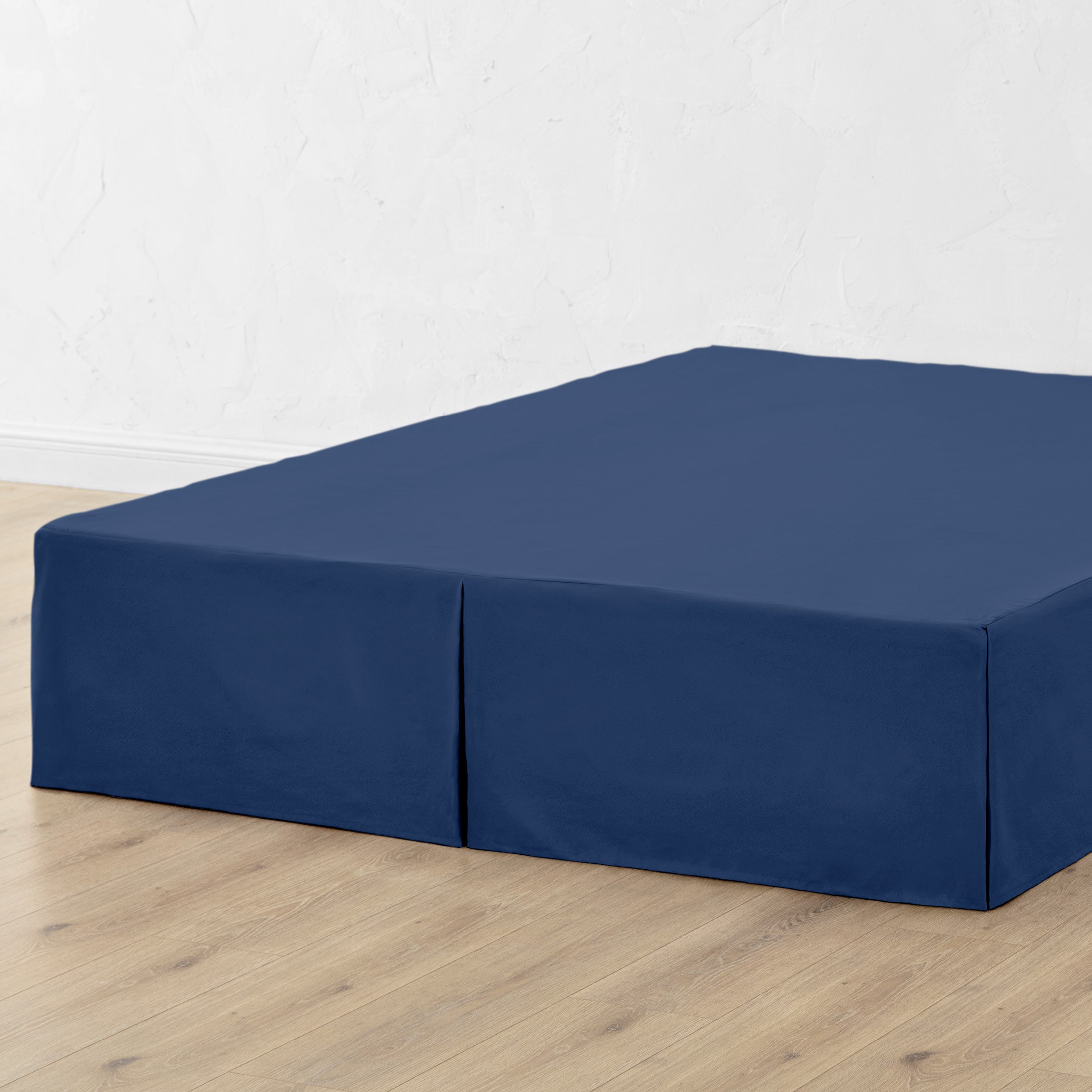 A bed skirt draped over a box spring