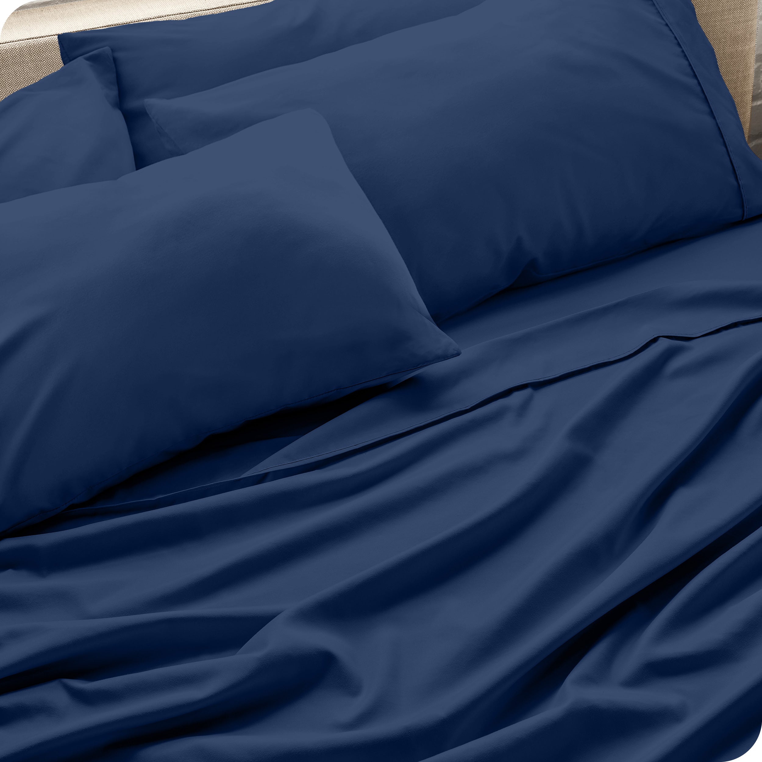 Close up of the microfiber bed sheets on a bed with four pillows.