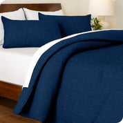 A side view of a modern bed with a comforter set and pillow shams on the bed
