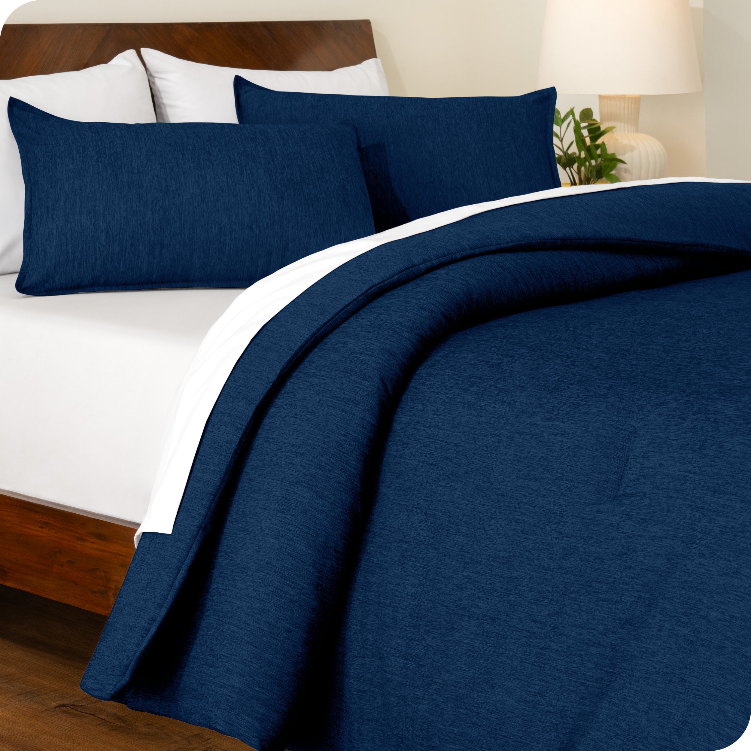 A side view of a modern bed with a comforter set and pillow shams on the bed
