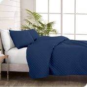 A coverlet set on a bed next to a window