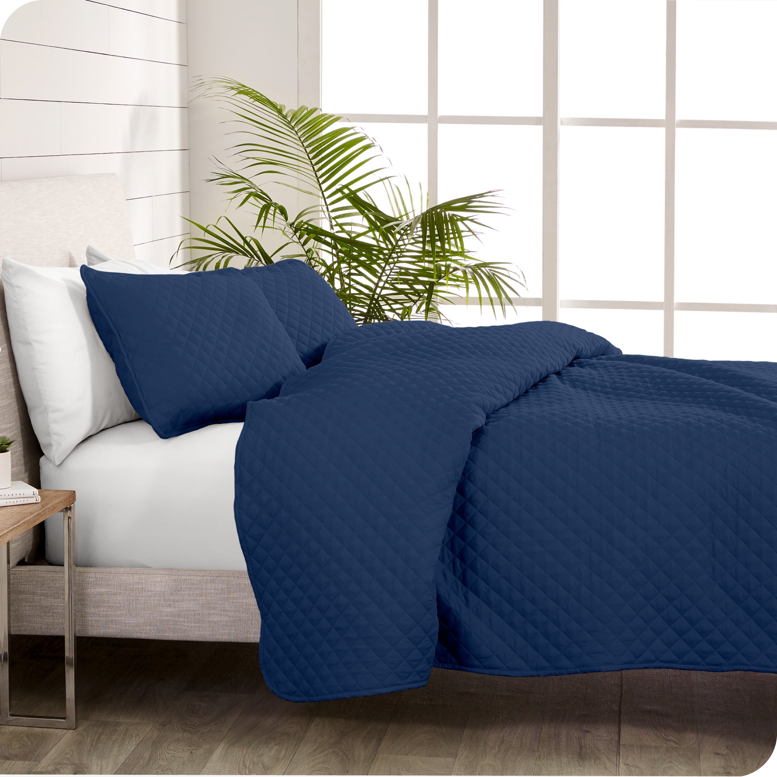 A coverlet set on a bed next to a window