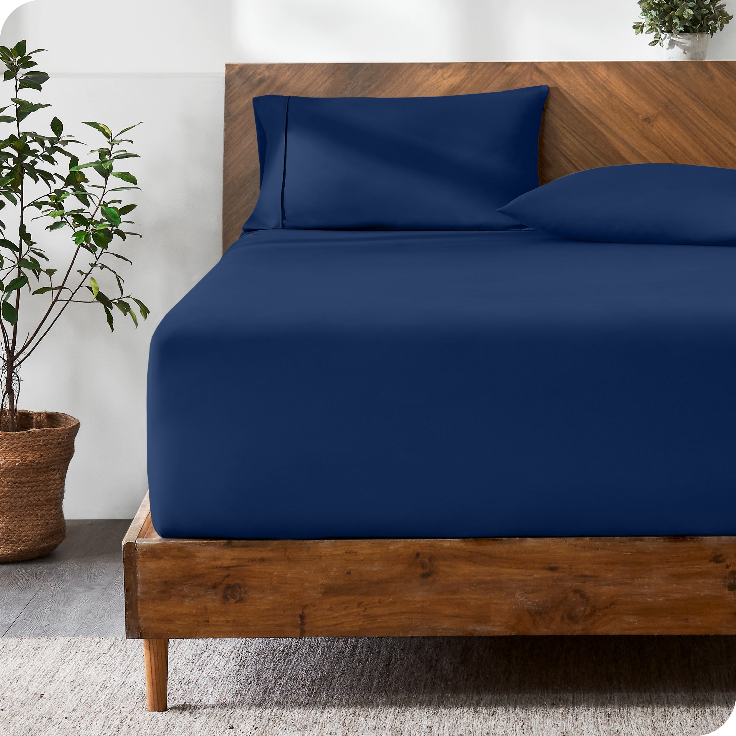 A modern bed with a fitted microfiber sheet made on the mattress. 